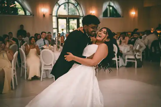 Bride and groom laughing together on the dance floor during their reception
